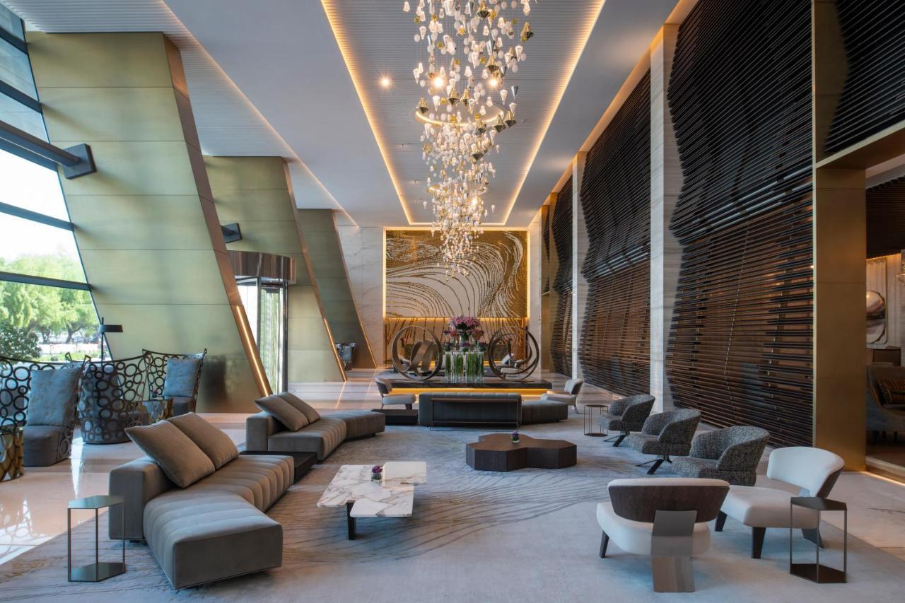 Steigenberger Hotel Ad Dawhah Esterno foto The photo depicts a modern and stylish hotel lobby. It features a spacious interior with elegant design elements. Prominent highlights include:

- A large, artistic chandelier hanging from the ceiling, providing ambient lighting.
- A central seating 